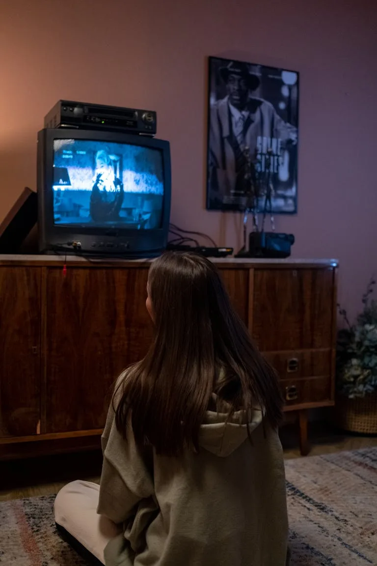 Girl watching TV, probably listening to a song synced into the show through sync licensing.