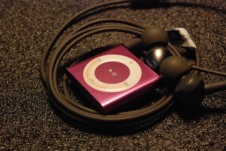 Reproductor MP3 con audífonos de cable, cuya función es reproducir masters de canciones digitalmente