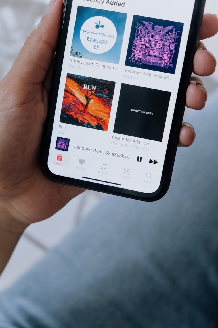 Persona reproduciendo música en su celular, utilizando plataformas de streaming